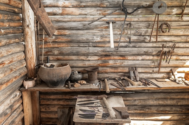 Vista interna da antiga forja da vila As ferramentas do ferreiro estão sobre uma bancada de madeira