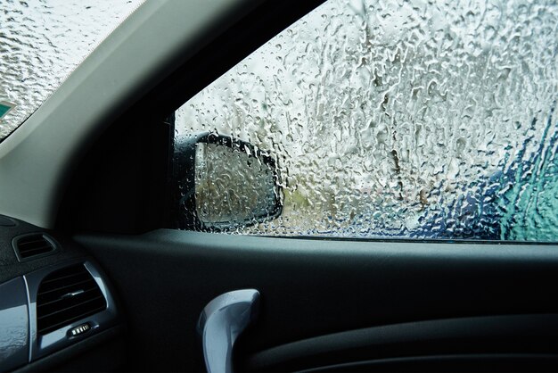 Vista interna do carro coberto pela chuva congelante. Gelo no pára-brisa de um carro.