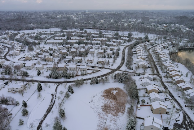 La vista invernal del pequeño complejo de apartamentos patios casas con techo de nieve cubierta