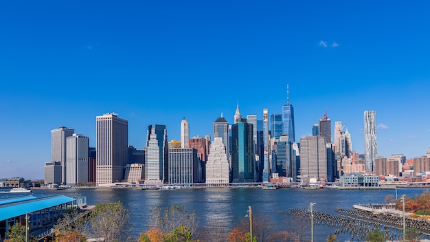 Vista de la isla de Manhattan, la ciudad de Nueva York desde el parque del puente de Brooklyn en un soleado día de otoño