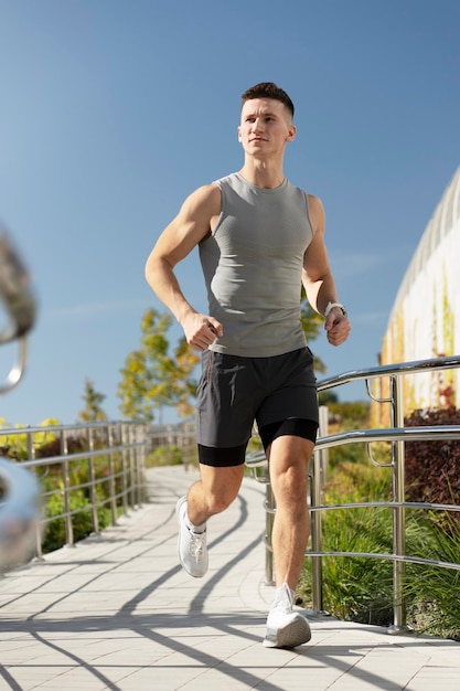 Vista del joven corriendo en la acera por la mañana Concepto consciente de la salud