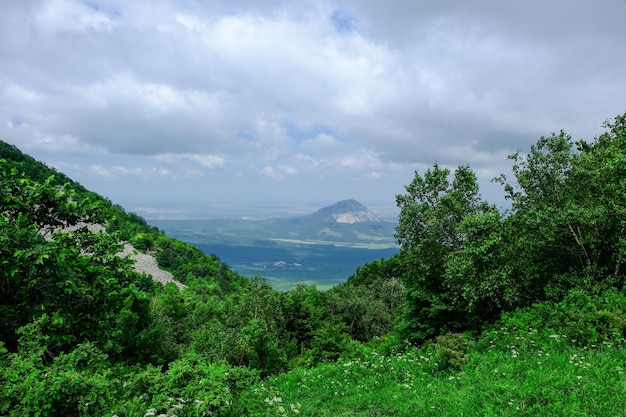 Vista de las laderas verdes de las montañas el valle y el cielo azul en las nubes