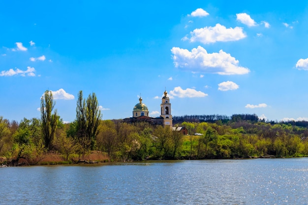 Foto vista del lago hermoso y de la iglesia ortodoxa vieja en una orilla