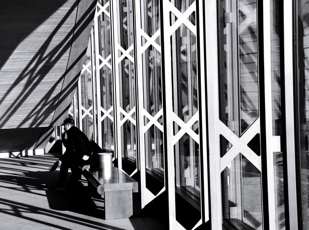Foto vista lateral de un anciano sentado en un banco en un edificio