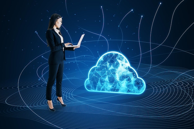 Vista lateral de una atractiva joven empresaria que usa una computadora portátil con una nube poligonal digital con líneas sobre fondo azul Concepto de computación y almacenamiento en la nube