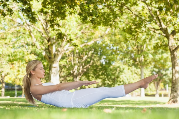 Vista lateral de la bella mujer haciendo yoga en un parque