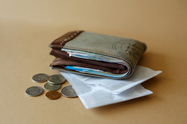 Vista lateral de la billetera con monedas de dinero y cheque de caja de la tienda