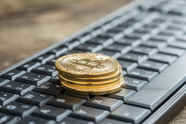 Vista lateral de bitcoins dorados en un teclado inalámbrico