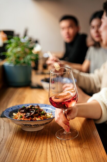 Vista lateral com uma taça de vinho e coquetel de aperitivos