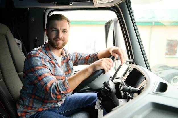 Foto vista lateral del conductor profesional al volante en la cabina del camión