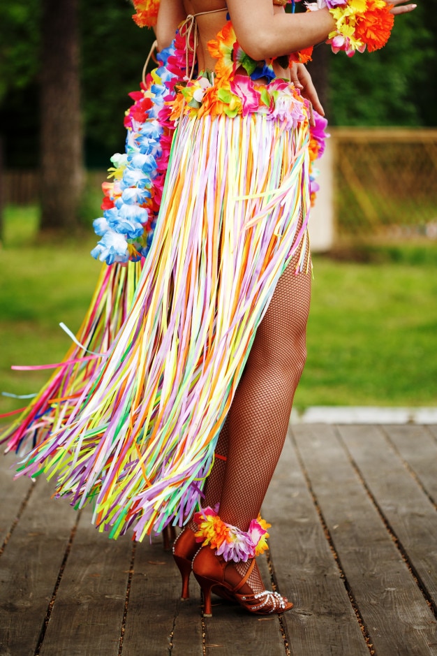 Foto vista lateral das pernas da mulher em traje havaiano