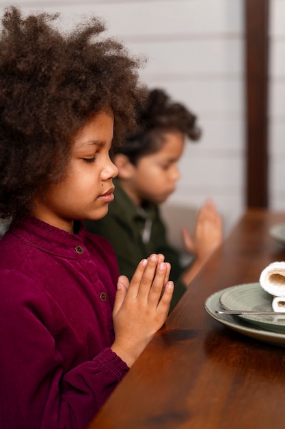 Foto vista lateral de crianças orando em casa