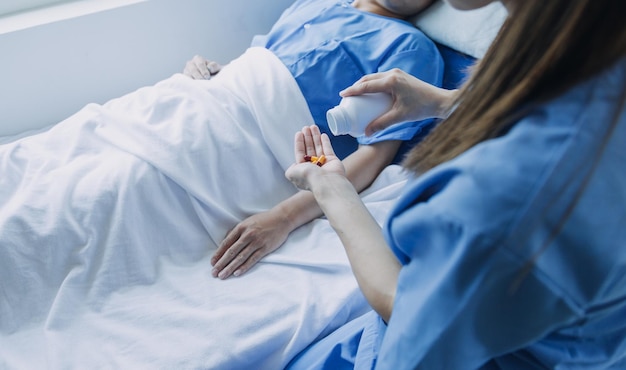 Vista lateral de diversos médicos examinando paciente do sexo feminino asiático na cama na enfermaria do hospital