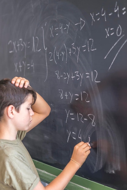 Foto vista lateral de um aluno masculino resolvendo um problema de matemática no quadro