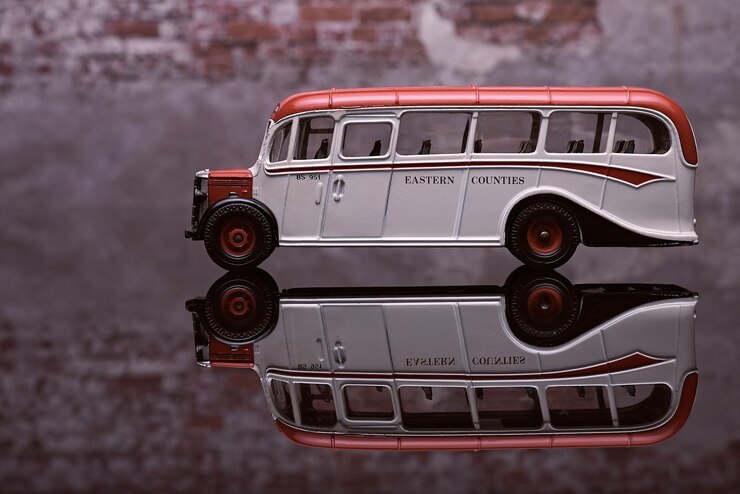 Foto vista lateral de um antigo ônibus britânico de um só andar com fundo de parede de tijolos