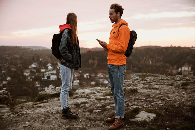 Foto vista lateral de um casal em uma viagem junto com uma bússola