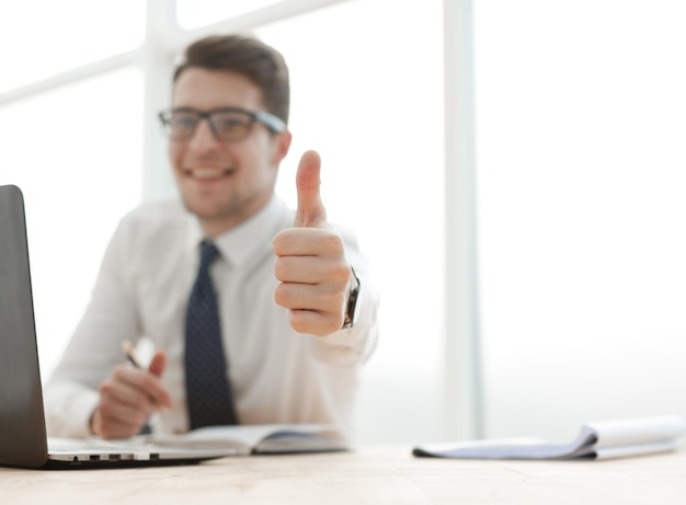 Vista lateral de um homem de negócios trabalhando no laptop e fazendo o gesto de ok