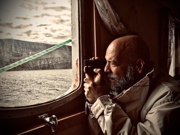 Vista lateral de um homem de pé em um barco