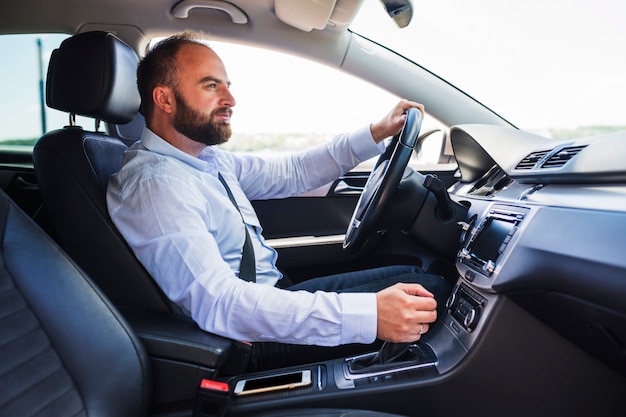 Vista lateral de um homem dirigindo um carro