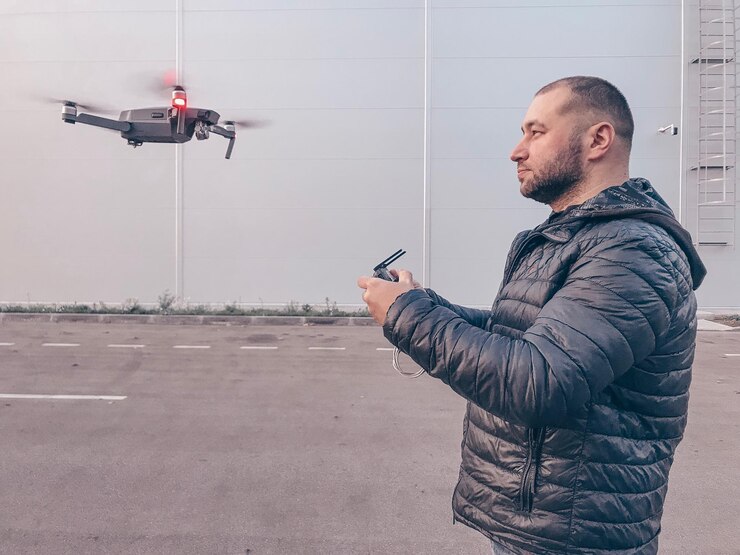 Foto vista lateral de um homem operando um drone com controle remoto na estrada