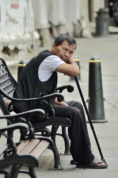 Foto vista lateral de um homem sentado no parque