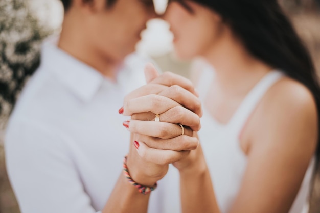 Vista lateral de um jovem casal de mãos dadas ao ar livre