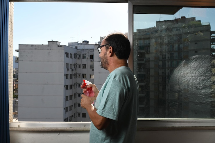 Foto vista lateral de um jovem de pé contra a janela