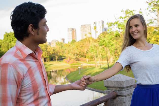 Foto vista lateral de um jovem sorridente de pé ao ar livre