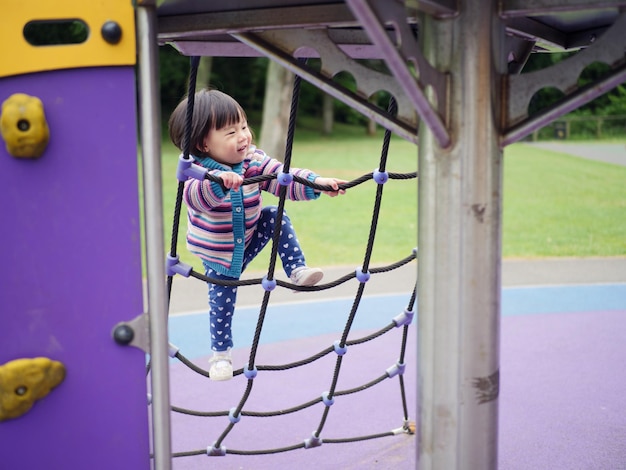 Vista lateral de um menino brincando no playground