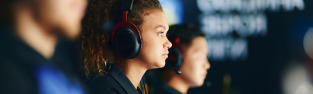 Vista lateral de uma jogadora de ciberesporte feminino de raça mista com fones de ouvido e jogando online