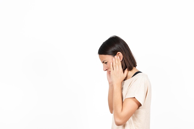 Vista lateral de uma jovem hispânica com as mãos nos ouvidos sofrendo dor de ouvido ou dor de ouvido