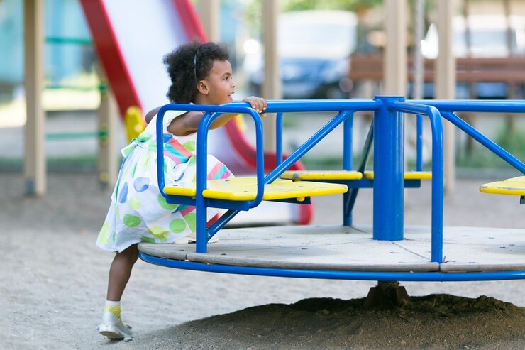 Foto vista lateral de uma menina brincando de carrossel no playground