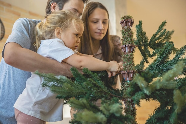 Foto vista lateral de uma mulher segurando uma árvore de natal