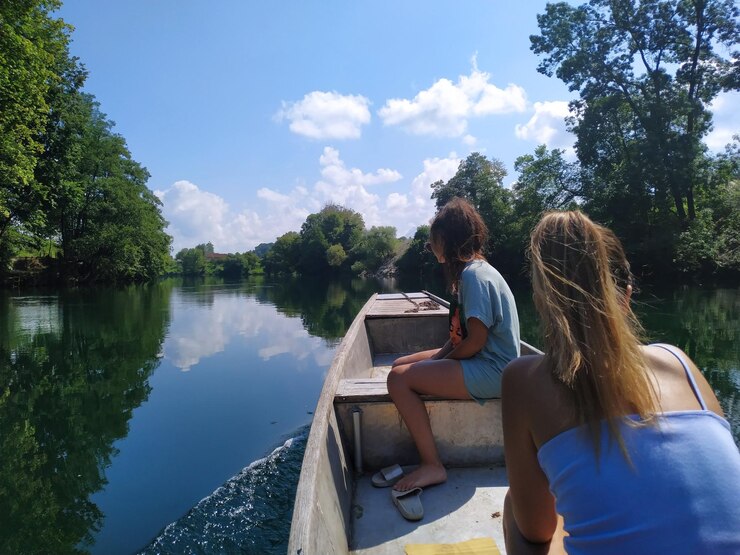 Foto vista lateral de uma mulher sentada em um barco fluvial