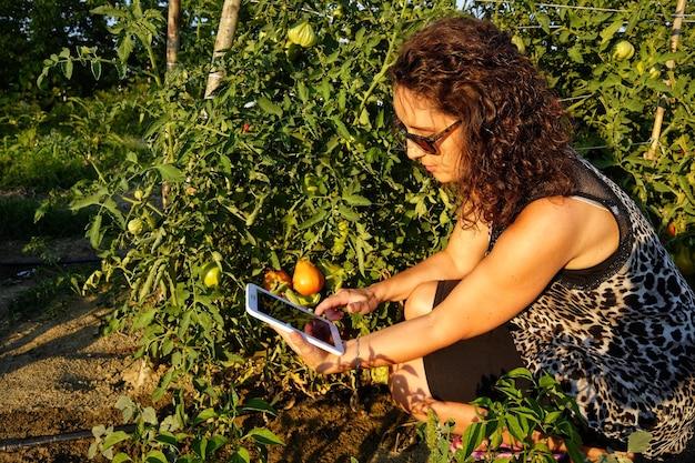 Foto vista lateral de uma mulher usando telefone móvel por planta
