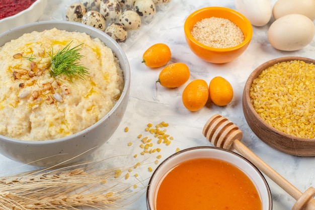 Vista lateral del delicioso desayuno con avena, huevos, arroz integral, miel sobre fondo de hielo