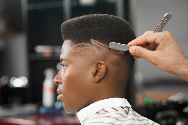 Foto vista lateral do homem com um corte de cabelo à moda na barbearia