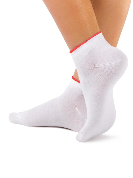 Vista lateral do pé de mulher bonita vestida com novas meias brancas em branco de tecido de algodão natural agradável e macio com debrum vermelho