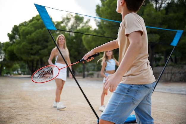 Vista lateral familia jugando bádminton