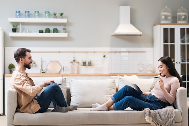 Foto vista lateral de la feliz pareja en el sofá de compras en línea