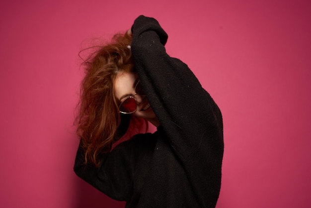 Foto vista lateral de una hermosa mujer joven contra un fondo rosa