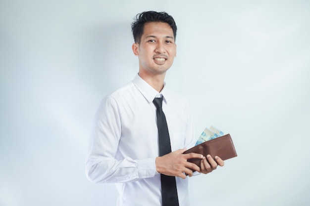 Vista lateral de un hombre asiático sonriendo feliz mientras saca dinero de su billetera
