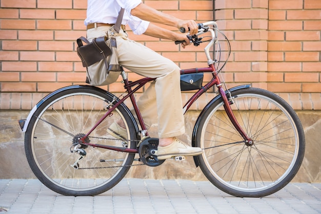 Vista lateral del hombre es andar en bicicleta en la calle.