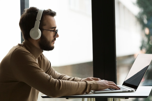 Vista lateral hombre de negocios con auriculares trabajando