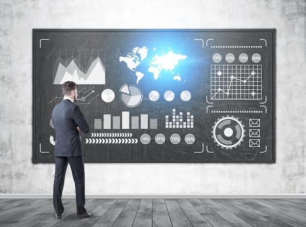 Vista lateral de un hombre de negocios pensativo mirando gráficos brillantes y un mapa del mundo en una pizarra en clase. Imagen tonada. Elementos de esta imagen proporcionados por la NASA