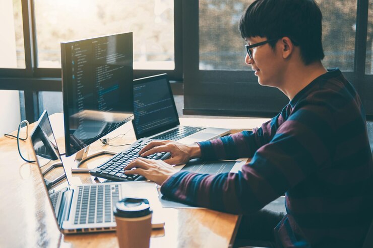 Foto vista lateral de un hombre de negocios usando la computadora en el escritorio de la oficina