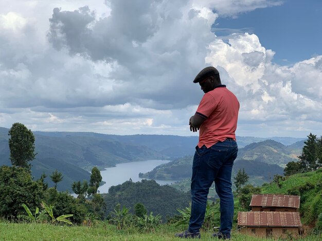 Foto vista lateral de un hombre de pie en la montaña contra el cielo