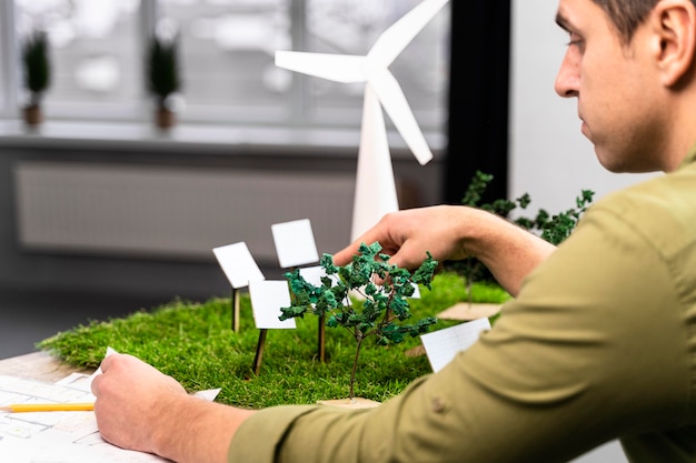 Foto vista lateral del hombre que trabaja en un diseño de proyecto de energía eólica ecológico