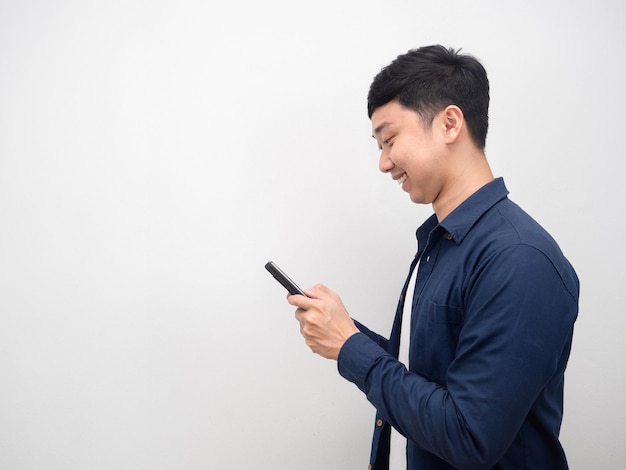 Vista lateral del hombre que usa el espacio de copia de emoción feliz de teléfono inteligente