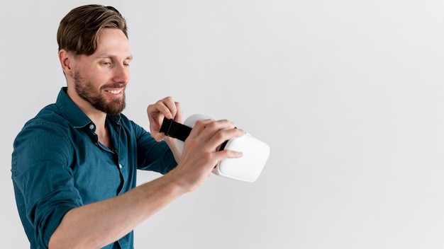 Foto vista lateral del hombre sonriente con casco de realidad virtual con espacio de copia